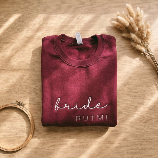 personalized embroidered bachelorette sweatshirts for bridesmaids laid flat with names