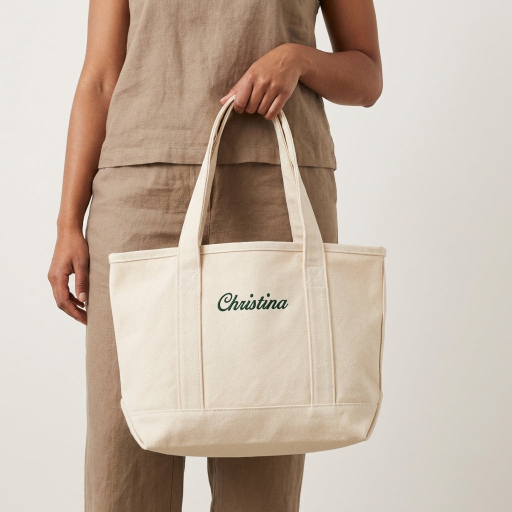 Model holding a natural tote bag with Christina name embroidery