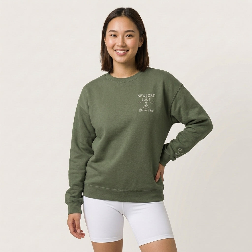 Model wearing a green personalized sweatshirt with front and sleeve embroidery